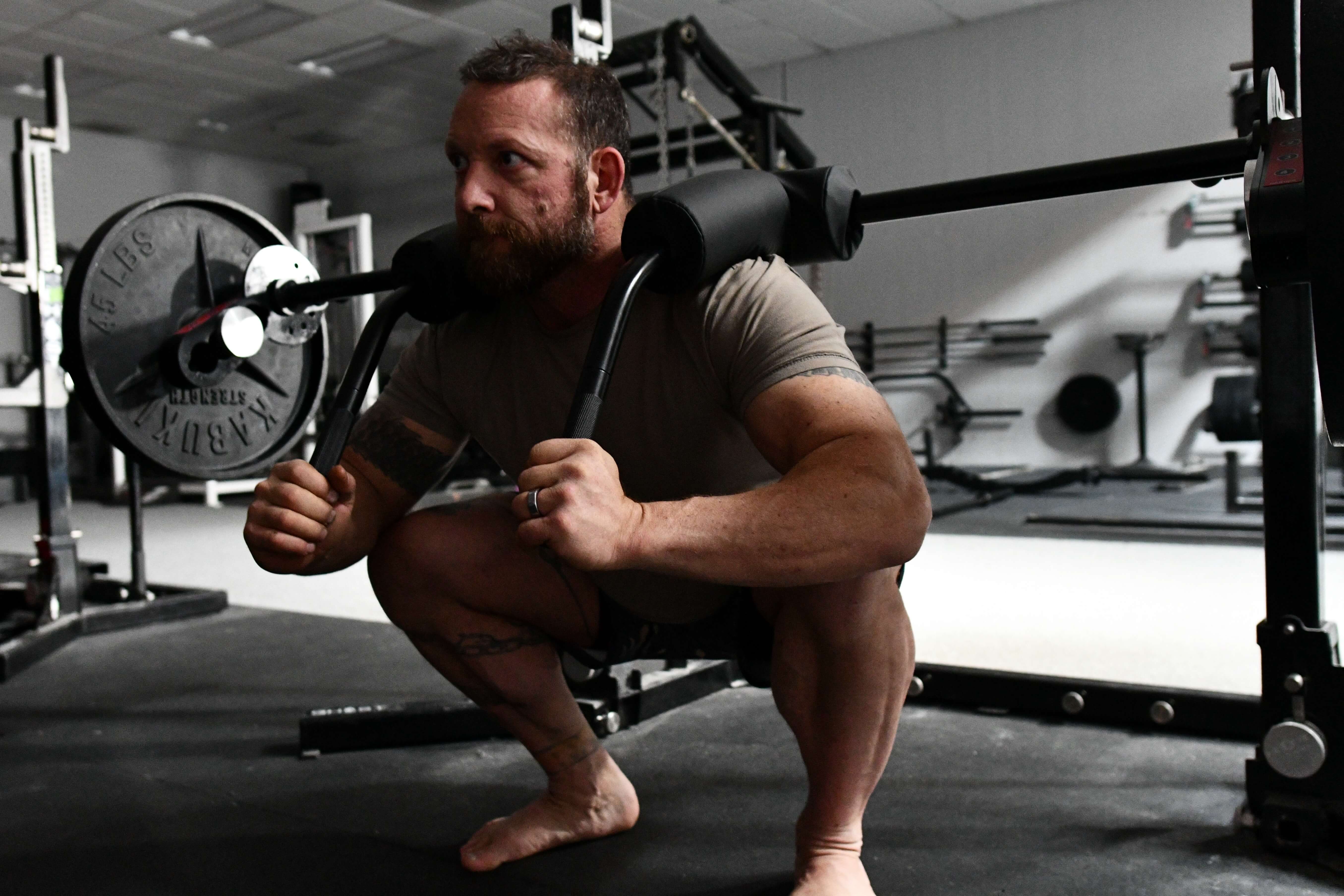 Man squatting with the Transformer Bar